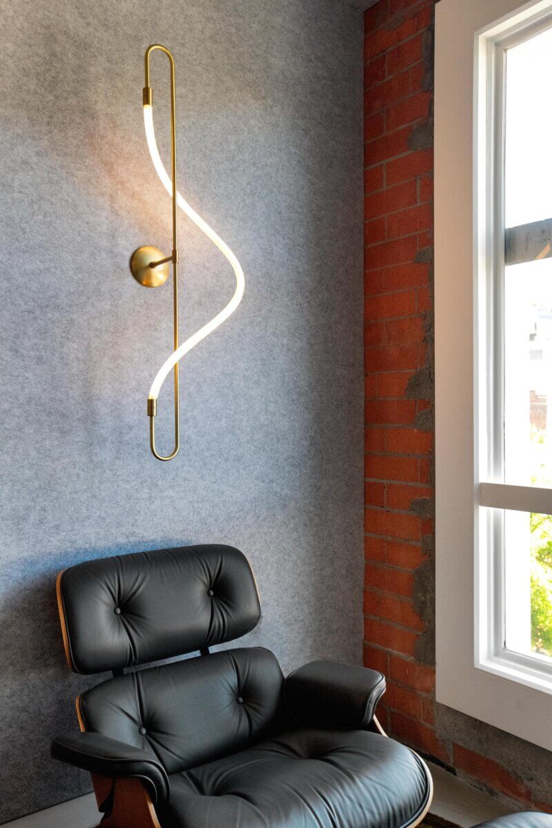 Designer lighting above an Eames lounge chair in a modern San Francisco office of a venture capital firm.