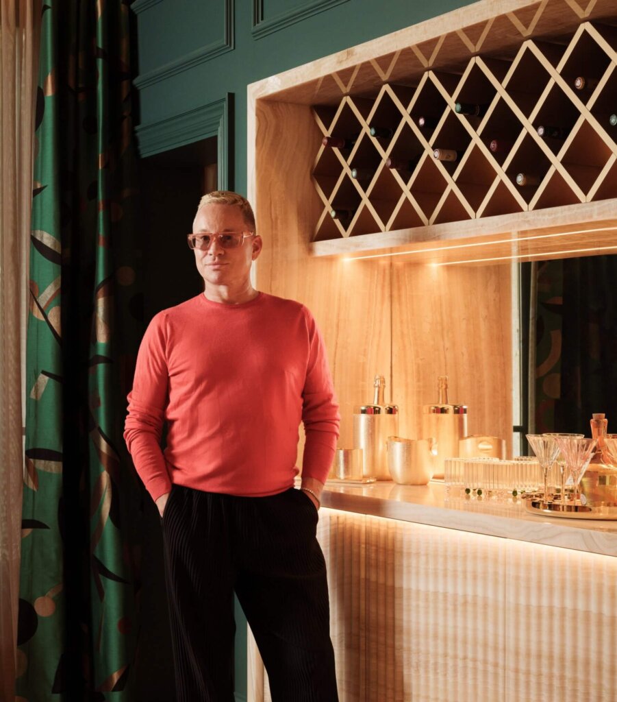 Mark Howorth posing by a luxurious, vintage bar.