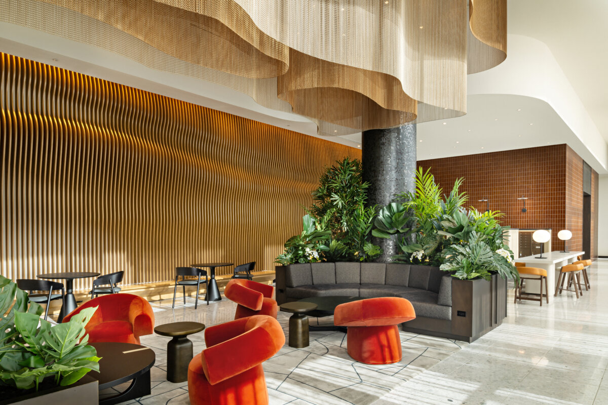 Modern, art deco lobby/lounge with orange seating against neutral colors. By Cetra Ruddy Architects.